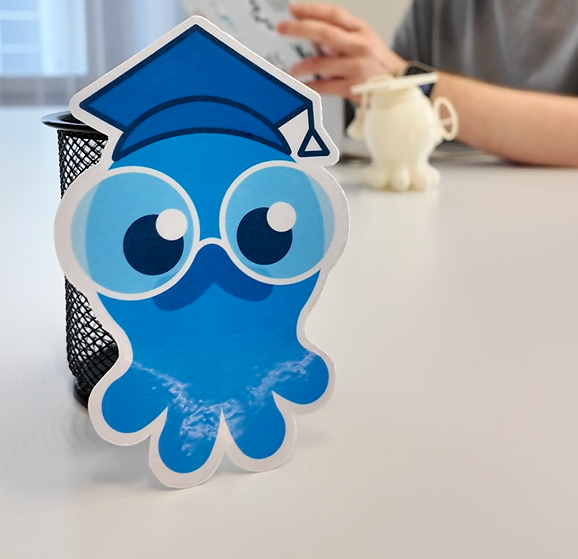 blue octopus, new face of the AI Buddy with Vinzent in the background on his iPad